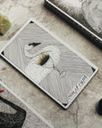 Set of tarot cards on a textured surface with crystals and a black swan card.